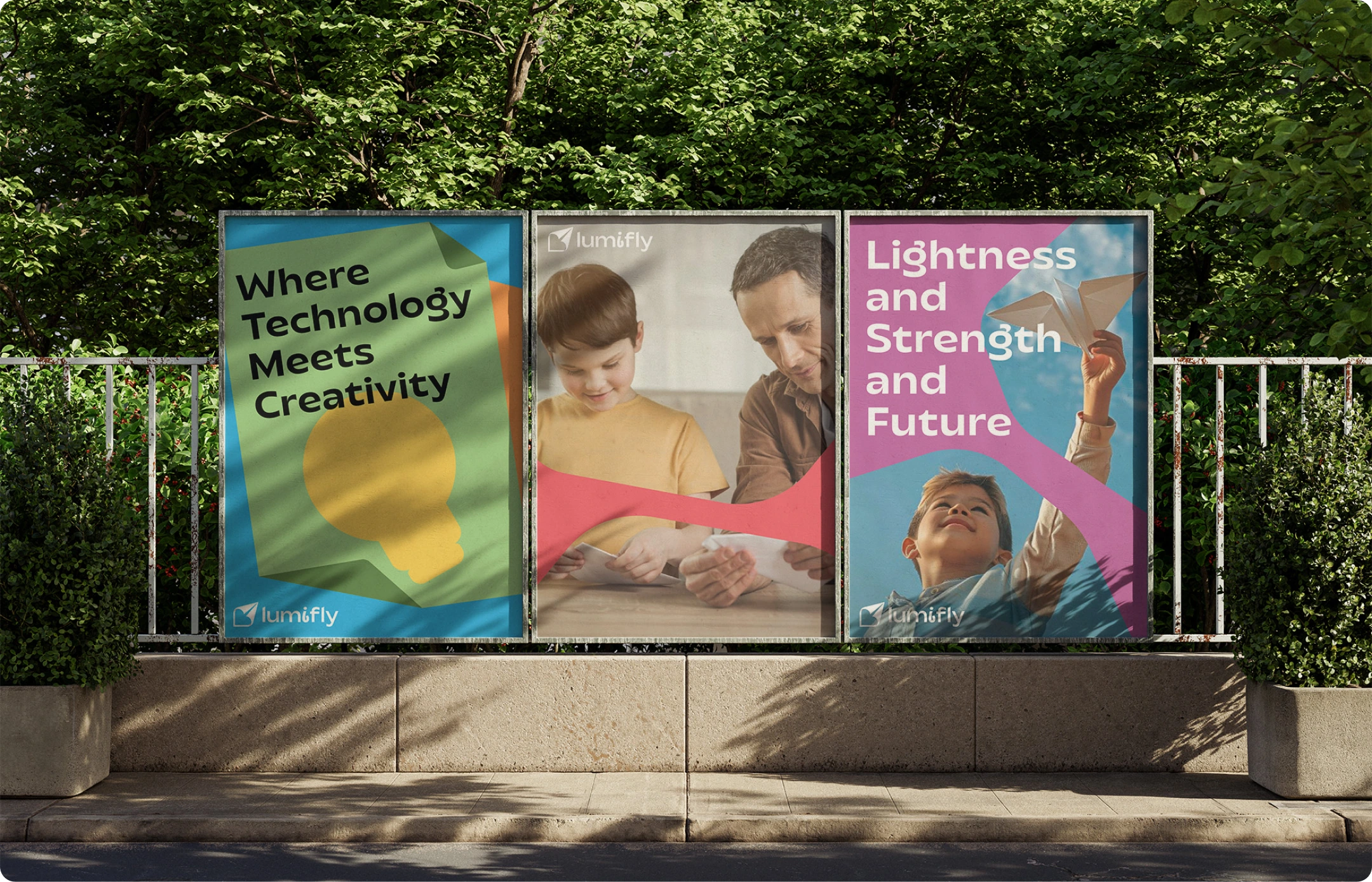 Lumifly outdoor advertising with three posters about creativity, technology and flight beside a tree-lined street